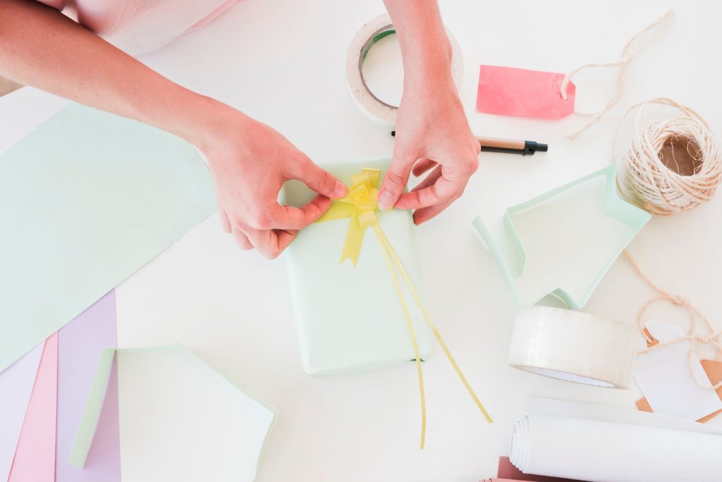 overhead-view-woman-sticking-yellow-ribbon-wrapped-gift-box.jpg overhead-view-woman-sticking-yellow-ribbon-wrapped-gift-box.jpg